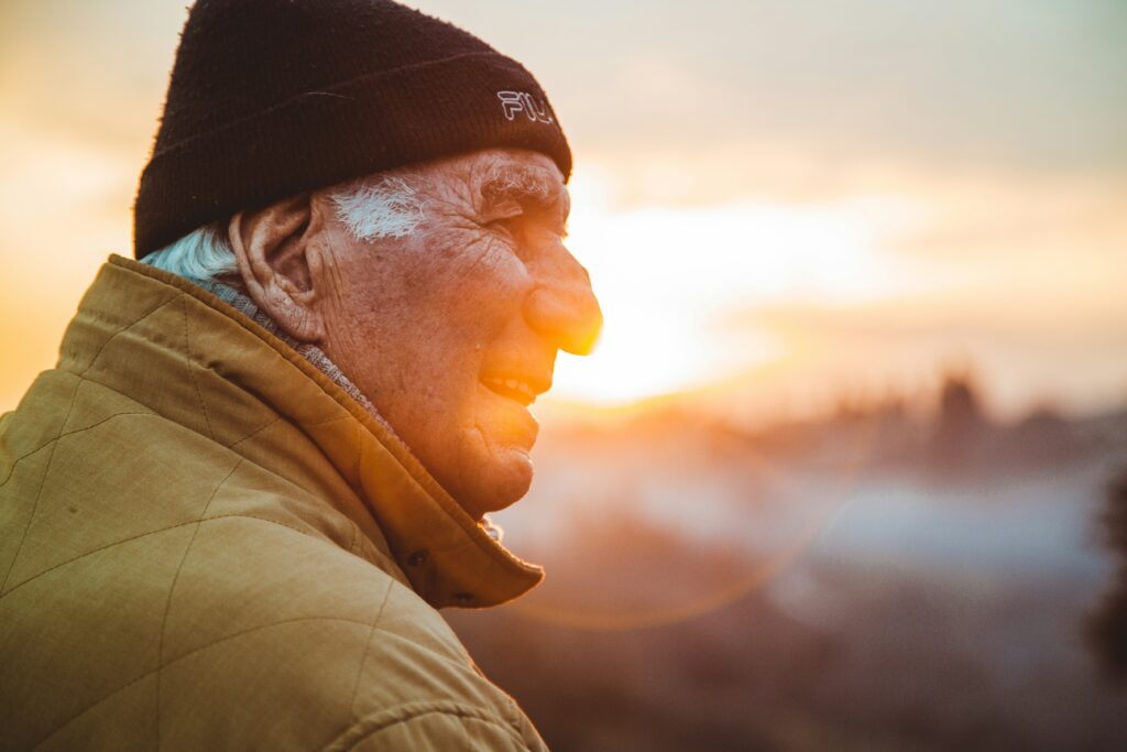 Mature man in warm jacket looking out at sunrise