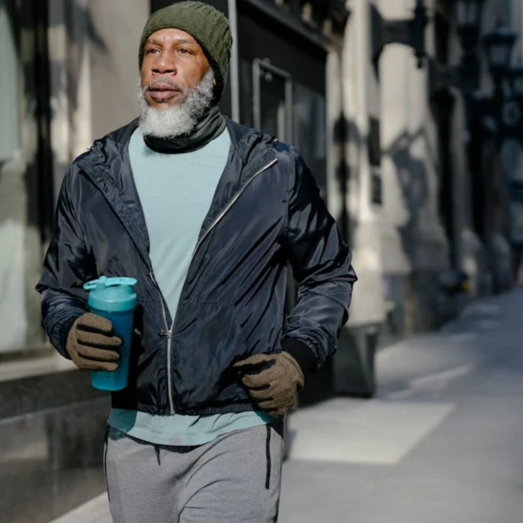 Man running outdoors in colder weather wearing warm exercise clothing