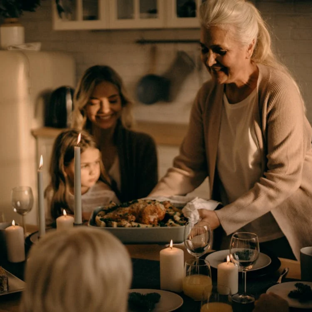 Woman setting a roasted turkey at a table with her family